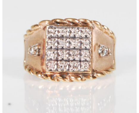 An English hallmarked 9ct gold ring having a square head set with 16 round cut diamonds having a further four diamonds to the