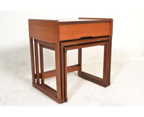 A 1960's retro vintage G-Plan teak wood nest of tables of graduating sizes. The largest table having a drawer and tile top ab