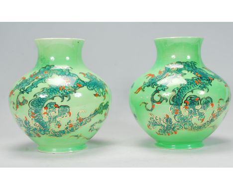 A pair of vintage 20th Century lustre Royal Art Pottery vases having light green ground with twin dragon decoration amongst t