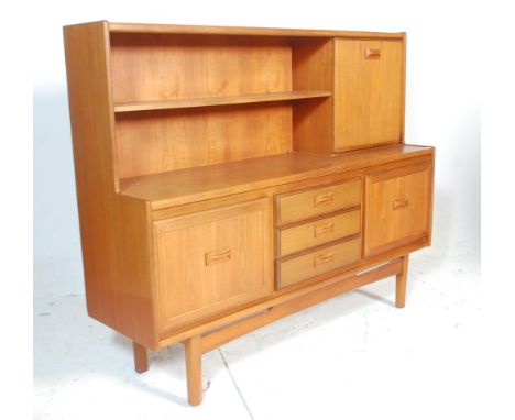 A 20th Century retro teak wood highboard sideboard credenza, having a configuration of three central drawers flanked by singl