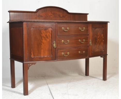 A 1920's mahogany bow front sideboard credenza, Raised on squared legs with pad feet. Above, a bow front sideboard with centr