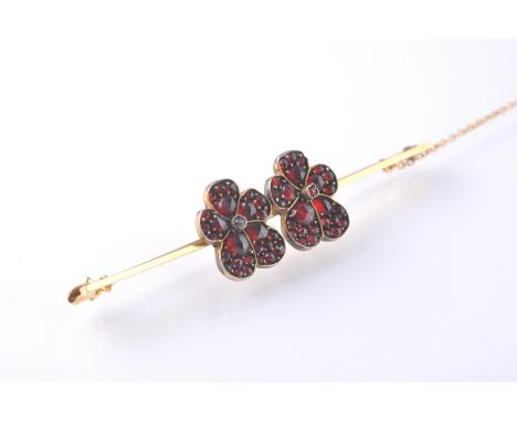 A late 19th / early 20th Century&nbsp;stamped 15ct gold bar brooch set with two silver flowers set with Bohemian garnets, saf