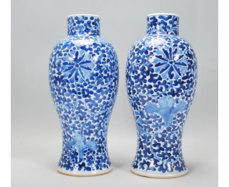 A pair of late 19th Century / early 20th Century Chinese blue and white vases having hand painted floral and scroll decoratio