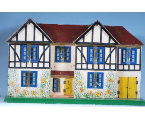 A vintage childrens circa 1950's dolls house of wooden painted construction having double opening facia together with a colle