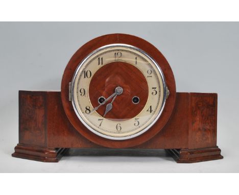 A 1930's Art Deco walnut mantel clock with silvered chapter ring, faceted hands set within an angular walnut case with steppe