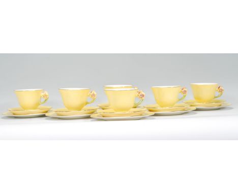 A vintage 20th Century Royal Winton hand painted tea service in the Petunia pattern having yellow ground with petunia handles