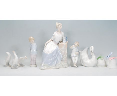 A selection of Lladro and Nao figurines to include a Nao Valencian girl with jug, three Lladro geese, a Lladro swan jug, a Ll