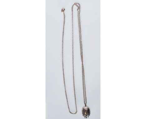 An English hallmarked silver fashion necklace having an egg shaped pendant with pierced decoration suspended on a fine double