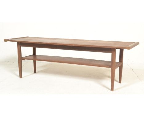 A 1960's retro vintage teak wood long john two tier coffee table having a long rectangular top with under tier, all raised on