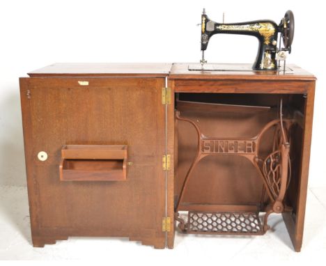 A 1930's Art Deco oak Singer Sewing machine cabinet / metamorphic table. The fold out door and hinge over fold top revealing 