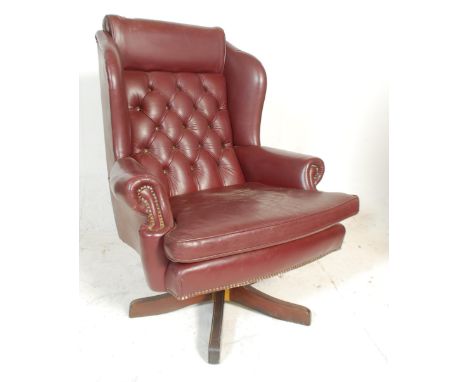 A vintage 20th Century Chesterfield style leather button back / wingback swivel armchair raised&nbsp;on five point splayed st