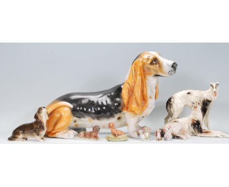 A collection of ceramic dog figurines to include a basset hound, two lurcher figurines marked RS, small dachshund figurines e