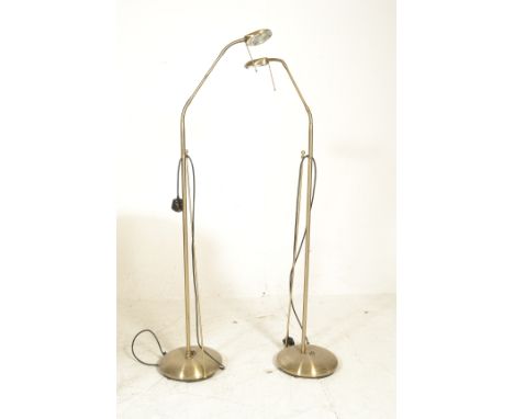 A pair of brass coloured vintage style free standing floor lamps raised on circular bases having metal upright tubular suppor
