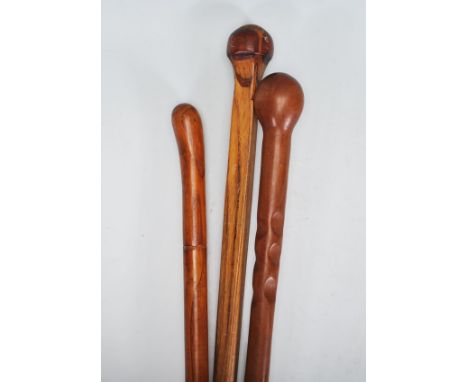 A group of three 20th Century carved wooden walking stick canes to include one carved with into a bamboo design, and two havi