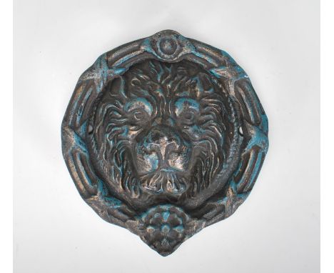 A large statement cast iron lion mask door knocker of round form having embossed lion mask to the back and swing knocker to t