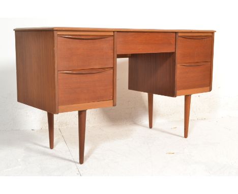 A 1970's retro vintage teak wood twin pedestal desk having two banks of two drawers to either side with a single drawer to ce