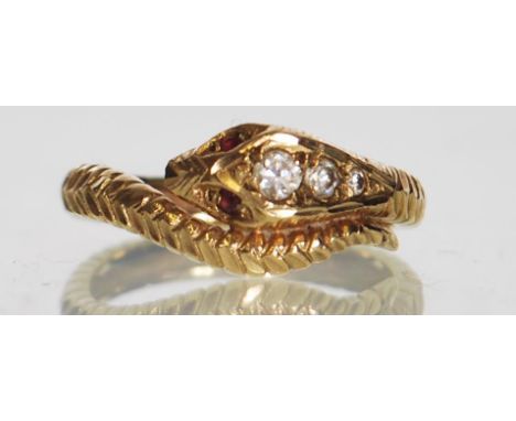 A hallmarked 9ct gold snake ring. The snakes head set with graduated white stones having ruby set eyes with diamond cut decor