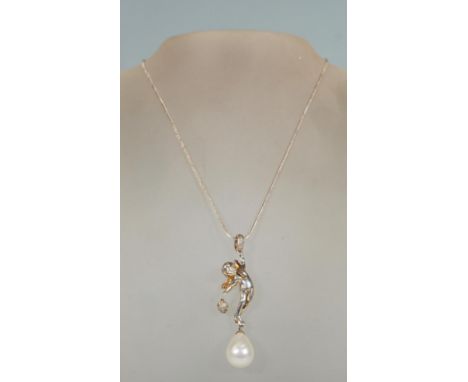 A silver pendant necklace in the form of a winged cherub set with white stones having a pearl droplet on snake link chain. St