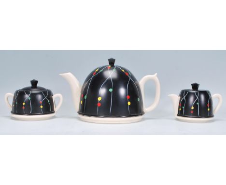 A retro vintage ceramic and aluminium tea set comprising of a teapot, creamer and sugar bowl each having ebonised aluminium c