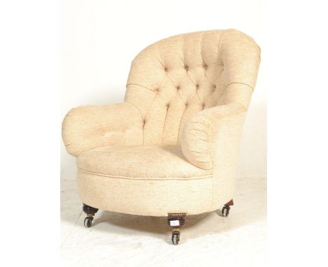 A 19th century Victorian mahogany upholstered armchair. Raised on brown ceramic castors to turned mahogany squat feet. Uphols