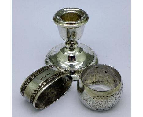 Two silver napkin rings and a small silver candlestick, weight of napkin rings 55g