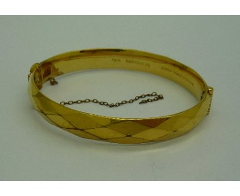A 9ct gold, metal core bangle