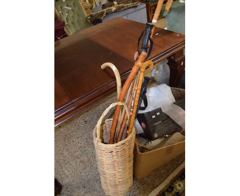 A wicker stick stand and various walking sticks