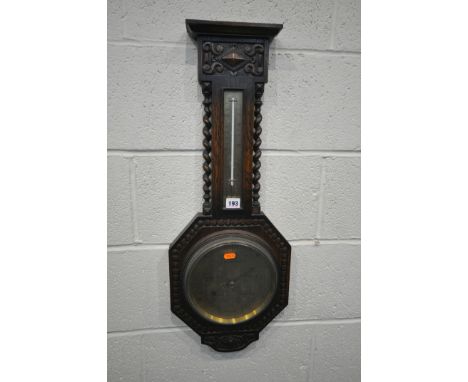 A 20TH CENTURY OAK BAROMETER, with spiral pillars flanking a thermometer, over a brass dial, height 76cm