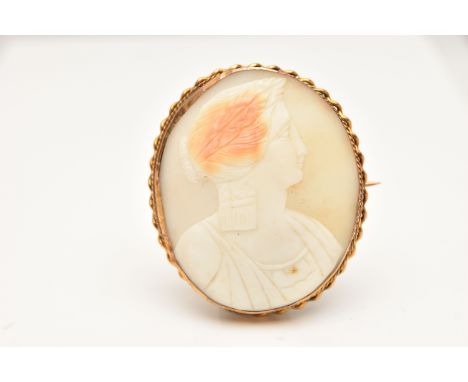 A YELLOW METAL CAMEO BROOCH, of an oval form, carved shell depicting a lady in profile, collet set within a rope twist surrou