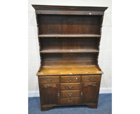 A REPRODUCTION GEORGIAN STYLE OAK DRESSER, the two tier plate rack with fifteen assorted hooks, atop a base with six drawers 