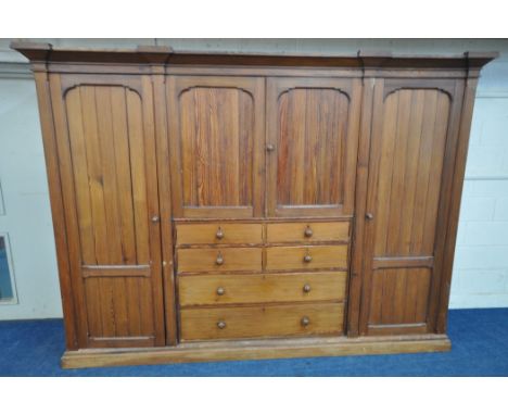 A 19TH CENTURY PITCH PINE WARDROBE, fitted with two large doors, flanking smaller double doors over six assorted drawers, wid