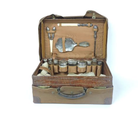An Edwardian crocodile skin dressing case, with silver mounted fittings, by Walker and Hall, London 1909, comprising nine gla