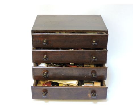 Clock and watch maker's spares in a four drawer cabinet, including watch parts, tools, spares, glasses, etc