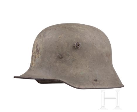 Stahlhelm M 16 Feldgrau lackierte Stahlglocke (berieben, Rostspuren), später nachgestrichen, stirnseitig noch Spuren eines Em