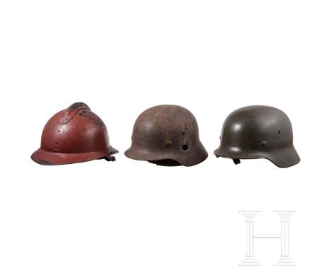 Drei Stahlhelme, westeuropäisch/deutsch, 1. Hälfte 20. Jhdt. Ein Stahlhelm Adrian M 26 (stirnseitiges Emblem fehlt), außen ro