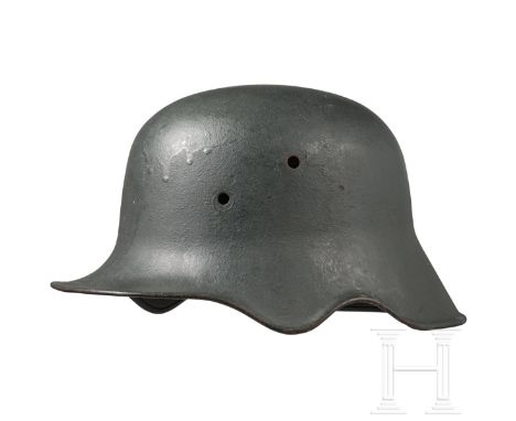 Stahlhelm M 18 mit Ohrenausschnitt Stahl mit gebördeltem Rand und rauer dunkelgrauer Oberfläche (partiell berieben, Rostspure