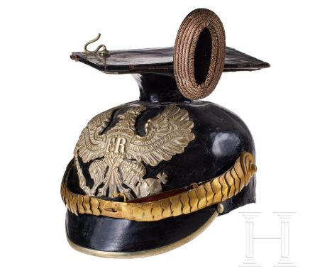 'A Prussian Line Uhlan Officer czapka, Service Black lacquered leather body (cracks in finish), rounded front visor; silver f