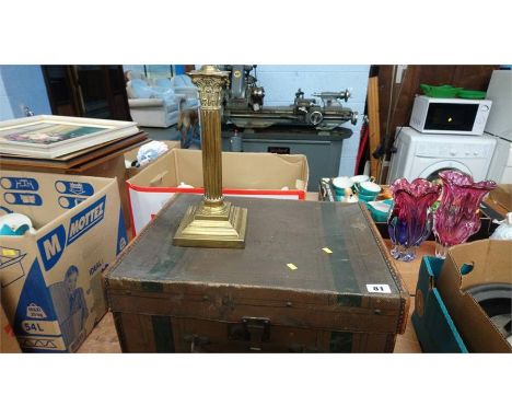 A canvas trunk and a brass candlestick