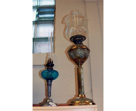 A Victorian brass paraffin lamp, together with an Edwardian lamp with moulded blue glass reservoir