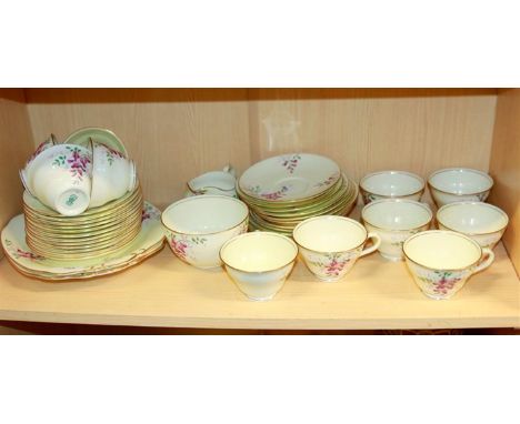 An early 20th century Coalport tea service, comprising eleven tea cups, twelve saucers, twelve side plates, two cake plates, 