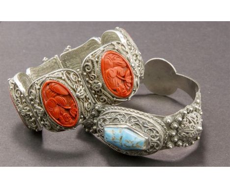 A Chinese silver and cinnabar lacquer panelled bracelet, the oval panels with carved figures in ceremonial costume, within fi