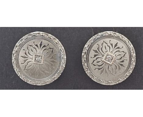 A pair of American Art Deco diamond set cufflinks, bi-coloured, the circular engine-turned plaques set with a central brillia