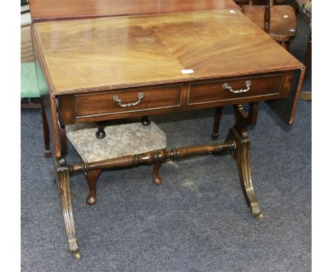 A reproduction mahogany sofa table, having two frieze drawers opposed by false on lyre end supports and sabre legs with brass