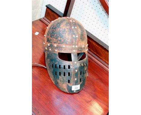 A reproduction rivetted steel Viking helmet with pierced face guard