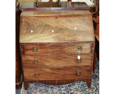A George III mahogany fall front writing bureau, with simple fitted interior above three long drawers, raised on shaped brack