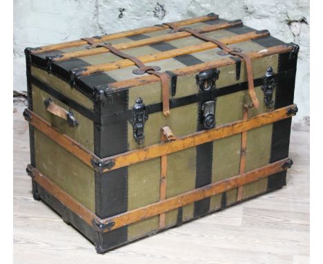 A vintage steamer or cabin trunk circa 1900, wood and metal bound with leather straps, each side with leather carry handles, 