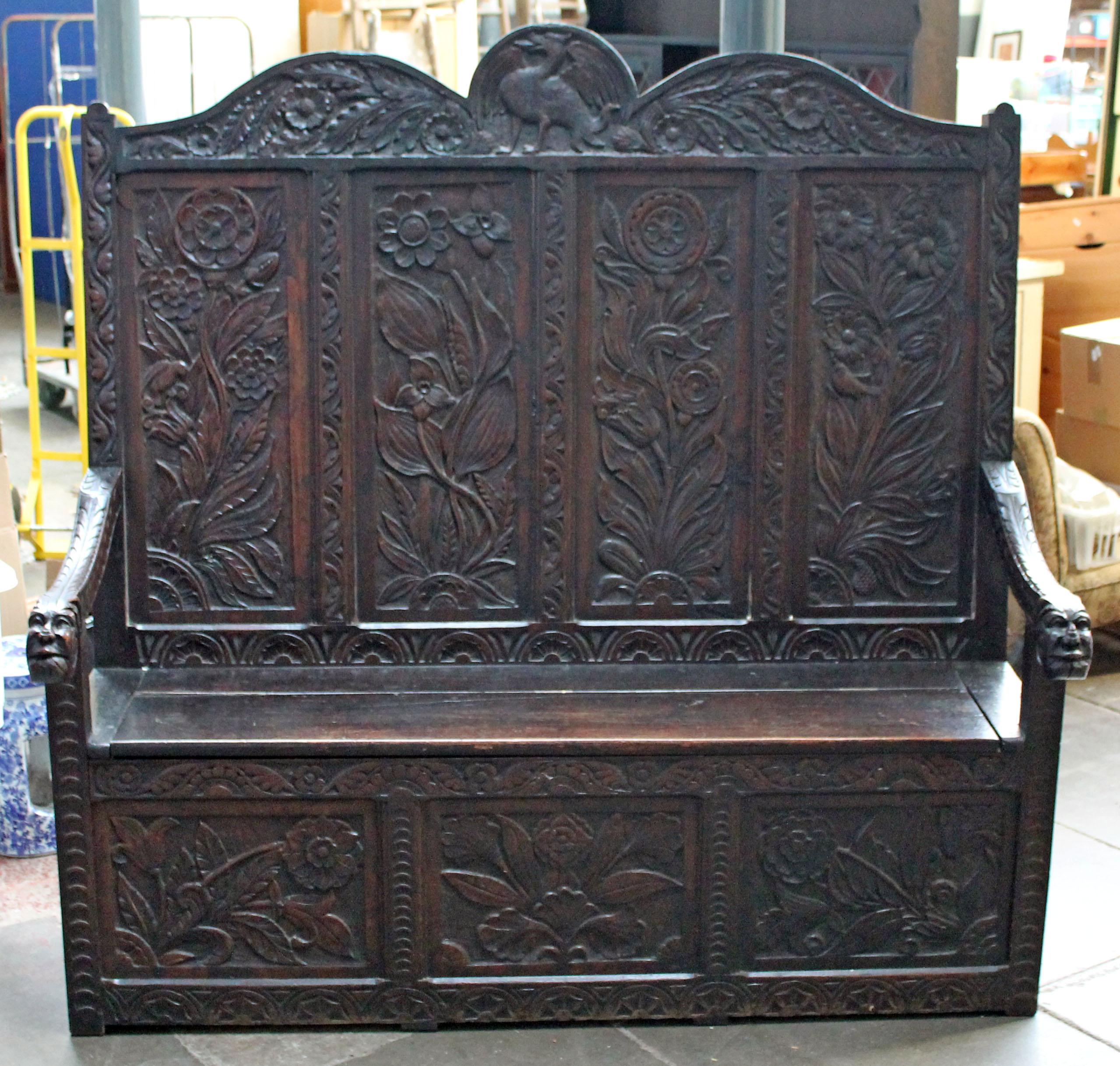A carved oak settle circa 1900, width 160cm, depth 60cm & height 158cm.