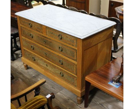 A Continental light oak chest of drawers with carrara marble top, the drawer fronts in bird's eye maple veneer crossbanded in