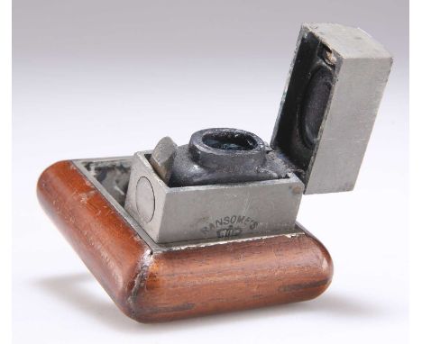 A RANSOME'S PATENT TRAVEL INKWELL fitted within a wooden border, further engraved 'DE LA RUE &amp; OR'. 6cm by 5cm