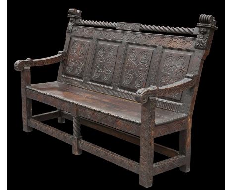 A VICTORIAN CARVED OAK SETTLE with four-panel back, bears carved initials TBA and date 1655. 116.5cm high, 164.5cm wide